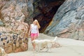 Blond girl walking with dog on the beach Royalty Free Stock Photo