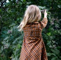 Girl in the garden collects burdock