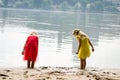 Blond girls in red dress and yellow dress at the river strand