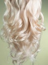 Blond Hair. Beautiful healthy long curly blonde hair close-up texture. Dyed Wavy white hair background, coloring, extensions, cure