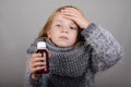 Blond hair little girl holding cough syrup in a hand. Sick child.. Child winter flu health care concept Royalty Free Stock Photo