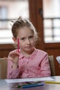 Blond hair school girl, sitting at the desk with school supplies Royalty Free Stock Photo