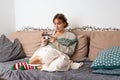 Blond young woman with sweater playing video game on her smart phone Royalty Free Stock Photo