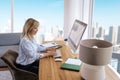 Blond haired mid aged businesswoman sitting at desk and using computer for work Royalty Free Stock Photo