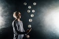 Blond juggler with white balls on black background Royalty Free Stock Photo