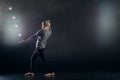 Blond juggler with white balls on black background