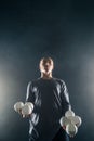 Blond juggler showing white balls on black background Royalty Free Stock Photo