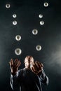 Blond juggler with white balls on black background Royalty Free Stock Photo