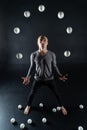 Blond juggler with white balls on black background Royalty Free Stock Photo