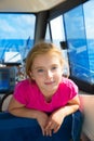 Blond kid girl at boat indoor sailing smiling happy Royalty Free Stock Photo