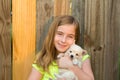 Blond kid girl hug a puppy dog chihuahua on wood Royalty Free Stock Photo
