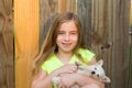 Blond kid girl hug a puppy dog chihuahua on wood Royalty Free Stock Photo