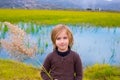 Blond kid girl outdoor holding spike in wetlands lake Royalty Free Stock Photo