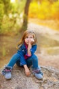 Blond kid girl pensive bored in the forest outdoor Royalty Free Stock Photo