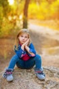 Blond kid girl pensive in the forest Royalty Free Stock Photo