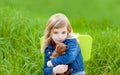 Blond kid girl with puppy pet dog in green grass Royalty Free Stock Photo