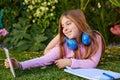 Blond kid girl selfie photo with tablet pc on grass