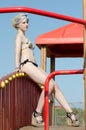 Blond lady with slim and athletic body wearing bikini having fun beside a fun park Royalty Free Stock Photo