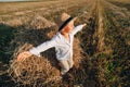 Blond little boy having fun jumping on hay in field. summer, sunny weather, farming. happy childhood. countryside Royalty Free Stock Photo