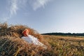 Blond little boy having fun jumping on hay in field. summer, sunny weather, farming. happy childhood. countryside Royalty Free Stock Photo