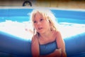 Blond little girl playing in the pool