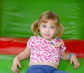 Blond little girl resting on colorful playground