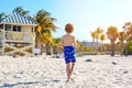 Blond little kid boy having fun on Miami beach, Key Biscayne. Happy healthy cute child playing with sand and running Royalty Free Stock Photo