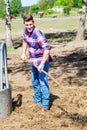 Blond man at farmland holdiing pitchfork