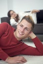 Blond man lying on carpet and woman sleeping on couch Royalty Free Stock Photo