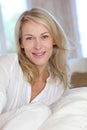 Blond mature woman sitting on sofa Royalty Free Stock Photo