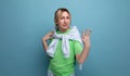 blond positive bright girl in a casual outfit shows three fingers on a blue background with copy space