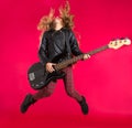 Blond Rock and roll girl with bass guitar jump on red Royalty Free Stock Photo