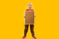 Blond schoolboy with empty board in his hands. Full-length portrait of young boy with blank board, yellow background. Copy space Royalty Free Stock Photo