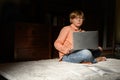 Blond serious boy spending time with notebook, sitting on the floor Royalty Free Stock Photo