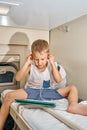 Blond-haired boy watches cartoons on tablet with headphones in train Royalty Free Stock Photo