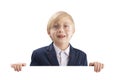 Blond smiling schoolboy in big glasses holds a large white poster. Boy with a billboard. Place for your text. Copy space