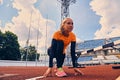 Blond sporty female runner to quick start position. Royalty Free Stock Photo