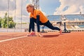 Blond sporty female runner to quick start position. Royalty Free Stock Photo