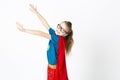 Happy and cool blond supergirl with glasses and red robe und blue shirt is posing in the studio Royalty Free Stock Photo