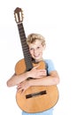 Blond teen boy holds guitar in studio against white background Royalty Free Stock Photo