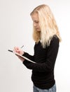 Blond Teen Girl Writing Notes On Notepad