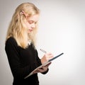 Blond Teen Girl Writing Notes On Notepad