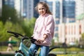 Blond teenage girl sitting on her blue bicycle, portrait outdoor Royalty Free Stock Photo