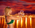 Blond tourist girl taking photos of Ibiza skyline