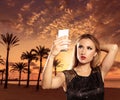 Blond tourist girl taking photos of Mallorca sunset