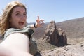 Blond Tourist taking selfie in Tenerife in the national park of el Teide in Llano de Ucanca with a big rock and arid, volcanic