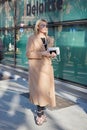 Blond woman with beige coat and velvet shoes before Giorgio Armani fashion show, Milan Fashion Week street