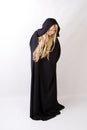 Blond woman in black hooded cloak looking down Royalty Free Stock Photo