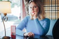 Blond woman in blue dress in cafe Royalty Free Stock Photo