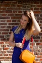 Blond woman blue dress orange handbag, Groot Begijnhof, Leuven, Belgium